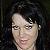 Chyna with her black hair, black shirt and black background.