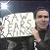 Eric holding a sign that says, 'RAW FEARS RATINGS'.